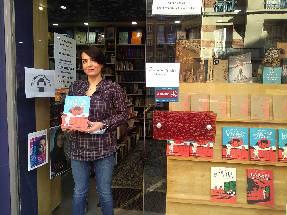 写真・図版 : イランと中東文化を紹介するペルシャ専門書店「Librairie Perse en
Poche」。店員さんが手にする本はリアド・サトゥフの人気自伝的コミック『未来のアラブ人5』=撮影・筆者
