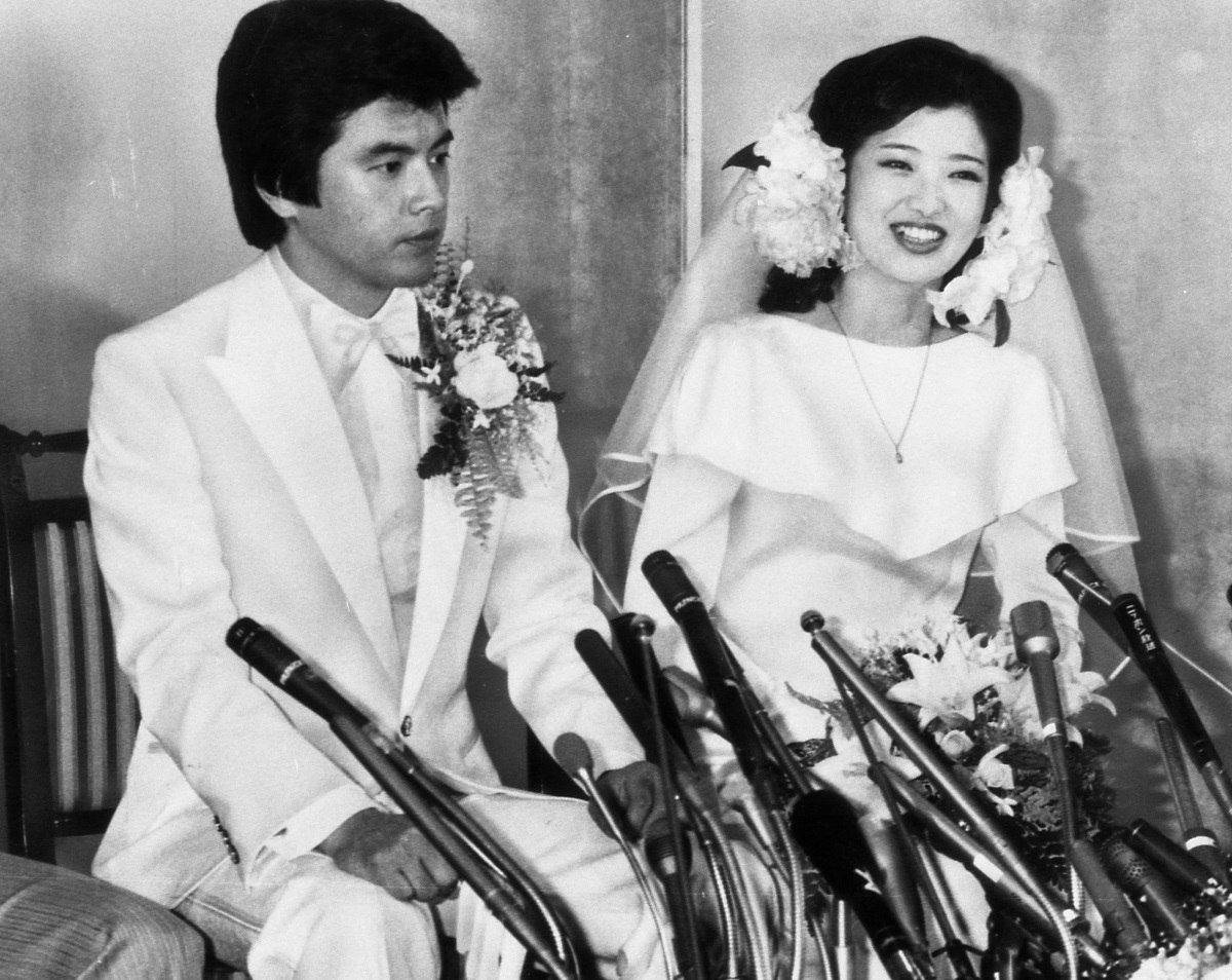 写真・図版 : 俳優の三浦友和さん(左)と結婚し、披露宴を前に記者会見に臨んだ山口百恵さん=1980年11月19日、東京都港区