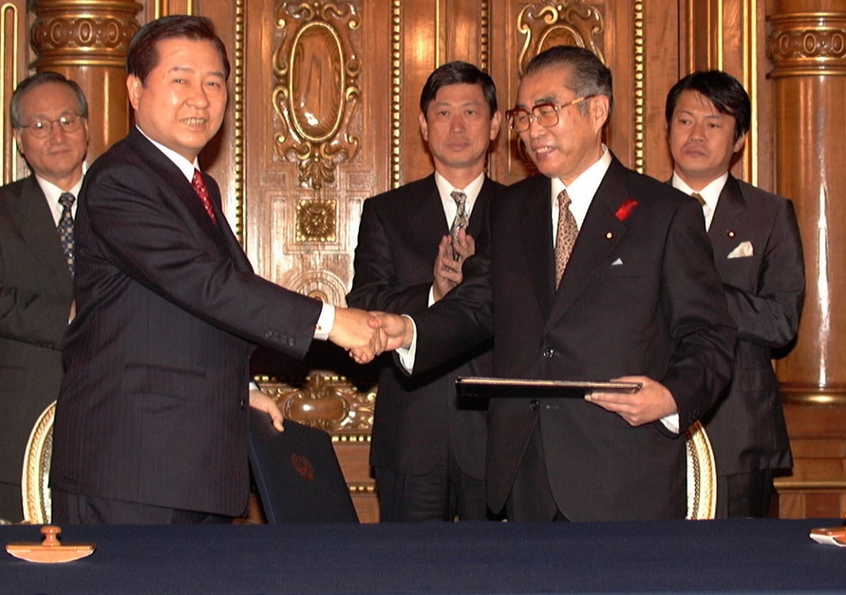 写真・図版 : 日韓共同宣言に署名し、握手する小渕首相(右)と金大中大統領=1998年10月8日、東京・元赤坂の迎賓館で(代表撮影) 