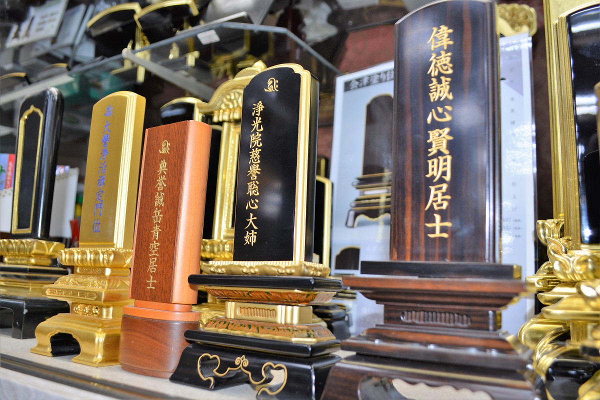 写真・図版 : 仏壇店に並ぶ位牌。戒名が見本として示されている=大阪市