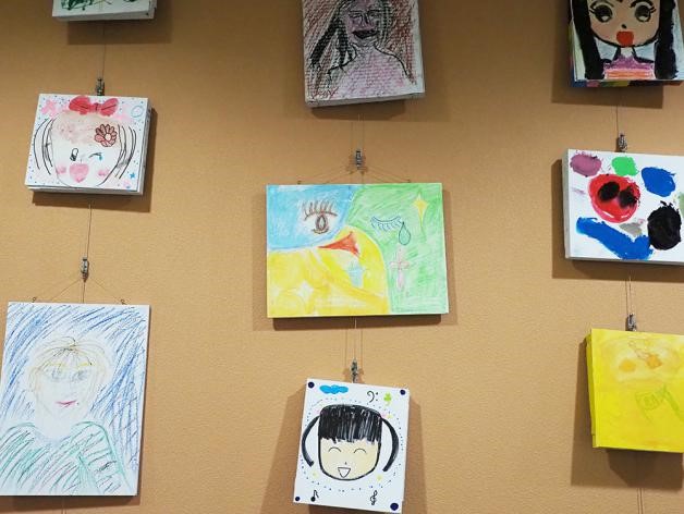 写真・図版 : とよなか国際交流センターの廊下には、子どもたちが描いた色とりどりの似顔絵が展示されていた