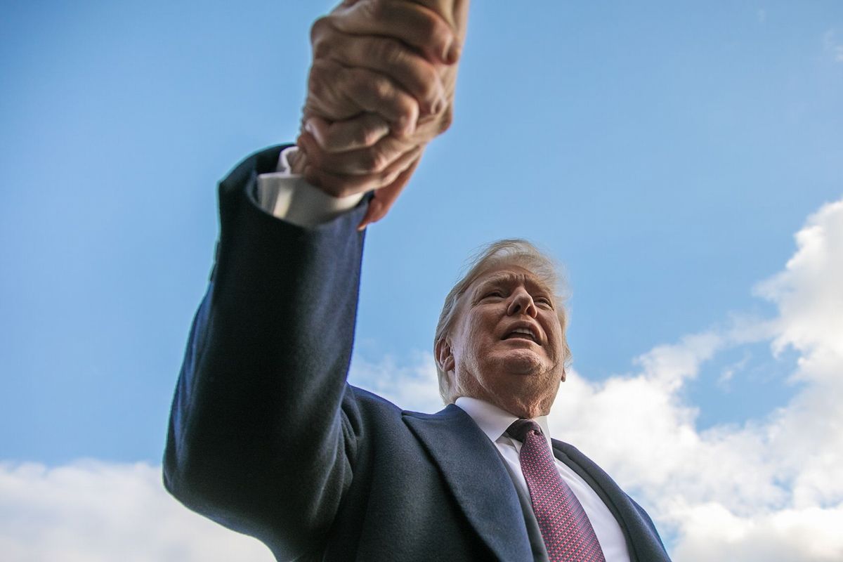 支持者の手を強く握り，自分のほうに引っ張るトランプ大統領。2018年11月20日、ホワイトハウスで、ランハム裕子撮影