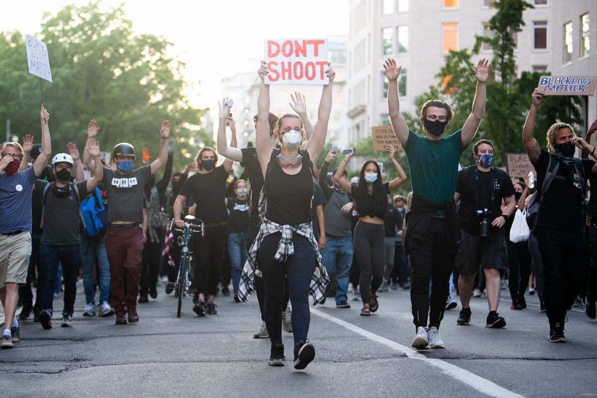 写真・図版 : 「両手をあげたら撃たないで」と叫びながら、抗議するデモ参加者たち。2020年6月2日、ワシントンで、ランハム裕子撮影