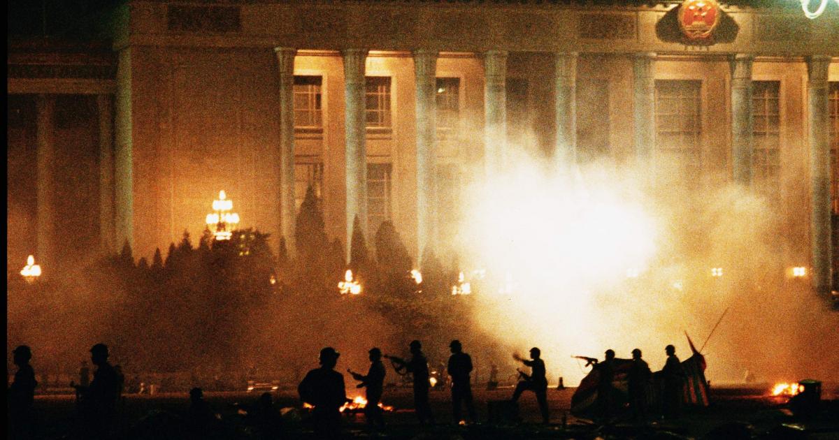 写真・図版 : 1989年6月3日未明、民主化を求めて北京の天安門広場で座り込みをしていた市民・学生に対し、戒厳軍が無差別銃撃を行った。6月4日午前5時ごろ、天安門広場を制圧したあとも、周辺に残る学生・市民に向かって発砲を続ける戒厳軍。後方の建物は人民大会堂=朝日新聞社