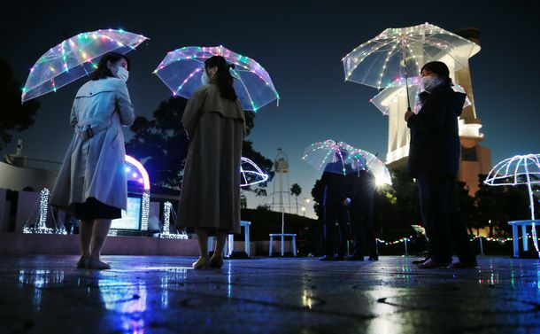 写真・図版 : 光る傘をさしてソーシャルディスタンスを取り合う人たち＝2020年11月26日、名古屋市港区、山本正樹撮影