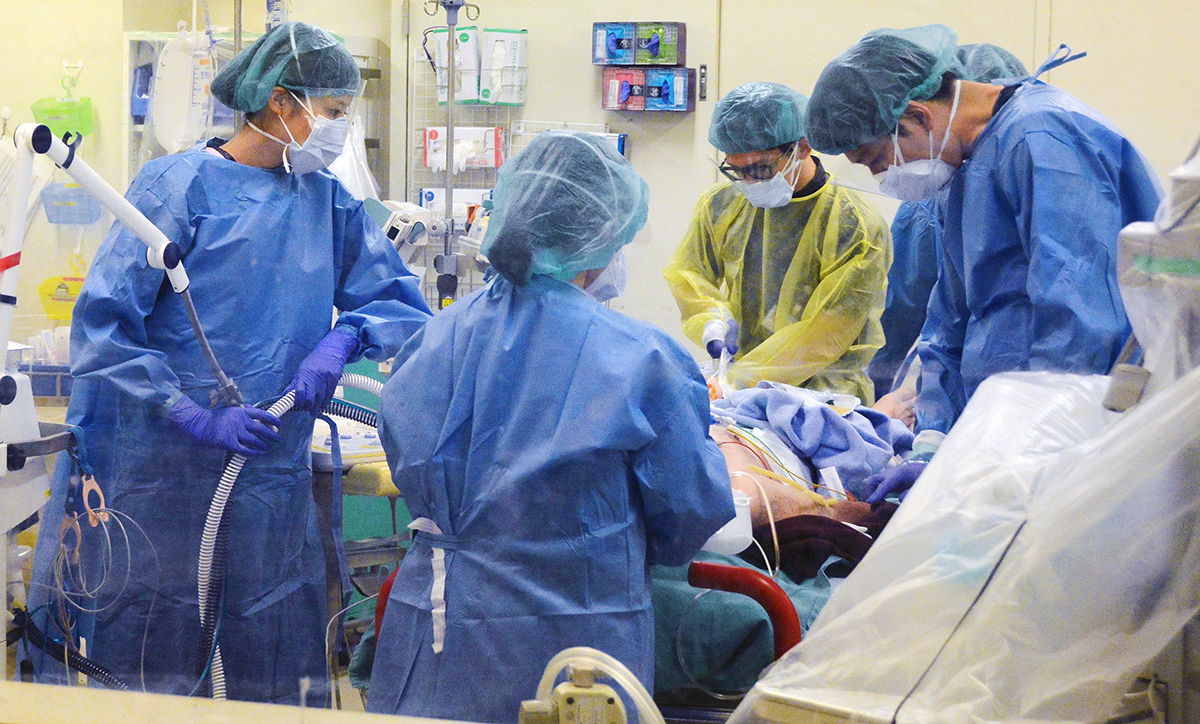 写真・図版 : 新型コロナウイルス感染症患者の処置にあたる医師ら＝2020年12月23日、福岡大学病院