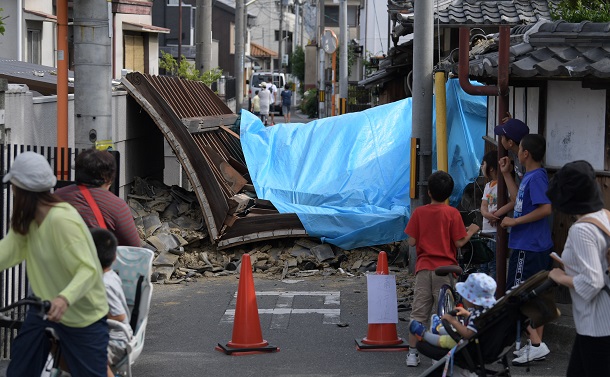 写真・図版 : 大阪北部地震で倒れて道路を塞ぐ寺の門＝2018年6月18日、大阪府茨木市 
