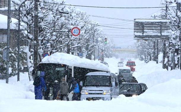 写真・図版 : 動けなくなったバスを押す後続車のドライバーら＝2021年1月11日、富山市内