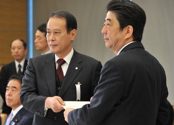 写真・図版 : 教育再生実行会議の鎌田薫座長（左）から提言を受け取る安倍晋三首相（当時）。世界大学ランキングの目標値を盛り込んだ提言は5月に手渡された＝2013年4月15日、首相官邸