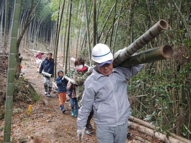 写真・図版 : 伐採した竹を運び出す人たち＝2017年2月、福岡市水源林ボランティアの会提供

