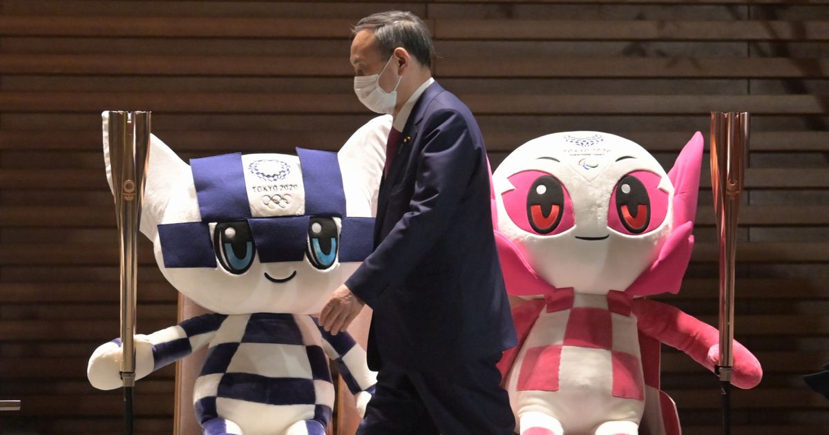 写真・図版 : 首相官邸を出る菅義偉首相。エントランスには東京五輪・パラリンピックのマスコット人形が飾ってある＝2021年1月22日