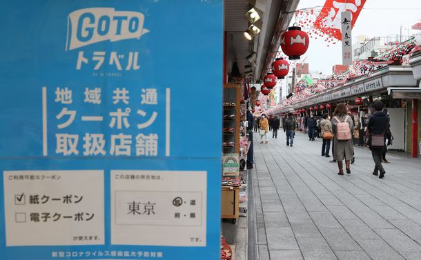 写真・図版 : 「Go　To　トラベル」一時停止。浅草・仲見世通りの店頭には、観光支援策ポスターが貼られたままになっていた＝2020年12月28日、東京都台東区 

