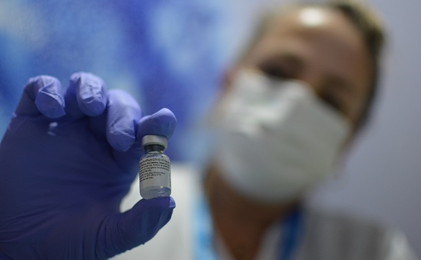 写真・図版 : 新型コロナウイルスの米ファイザー製のワクチンを手に持つ看護師＝2021年1月11日、イスラエル中部ネタニヤ