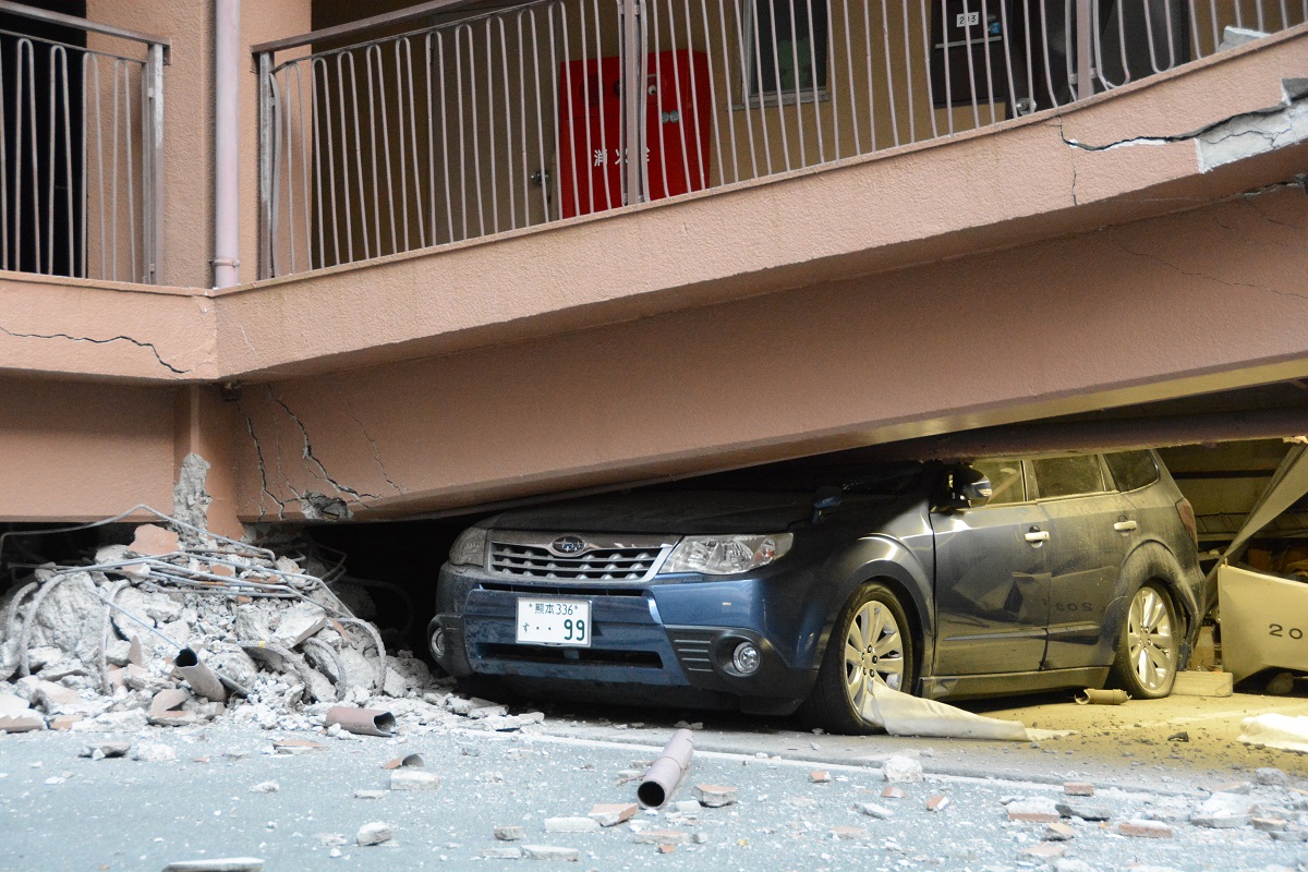 写真・図版 : 熊本地震で1階の駐車場部分（ピロティ）がつぶれたマンション＝2016年4月17日、熊本市西区 