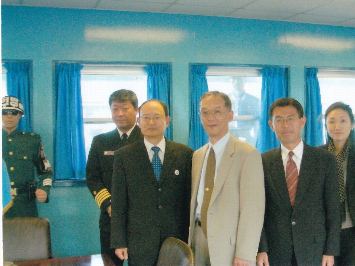 写真・図版 : 防衛政策局次長当時の黒江氏（右から３人目）が、韓国との定期協議の際に韓国側の相手（黒江氏の左）と板門店を訪問。窓の向こうに北朝鮮の兵士もいる＝2009年。黒江氏提供
