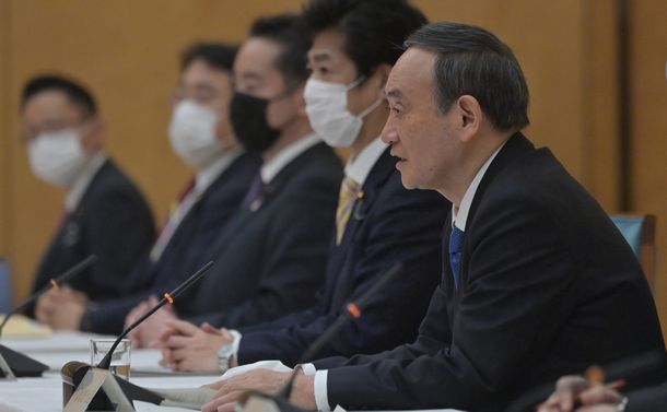 写真・図版 : 新型コロナウイルス感染症対策本部の会合で発言する菅義偉首相（手前）＝2021年2月12日、首相官邸