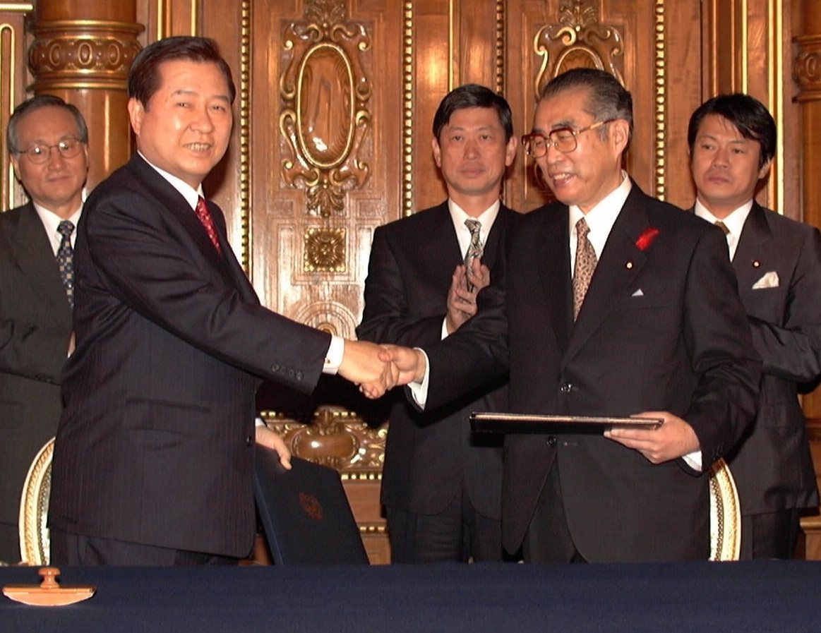 写真・図版 : 日韓共同宣言に署名し、握手する小渕恵三首相（右）と金大中大統領＝1998年10月８日、東京の迎賓館