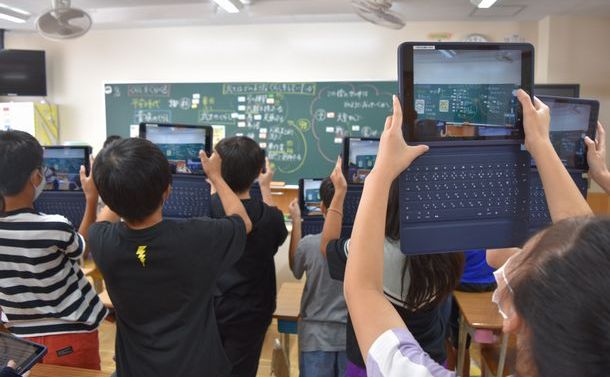 授業後、黒板の板書を「1人1台」のタブレット端末で撮影して保存する児童たち＝2020年10月2日、愛知県高浜市の高浜小学校