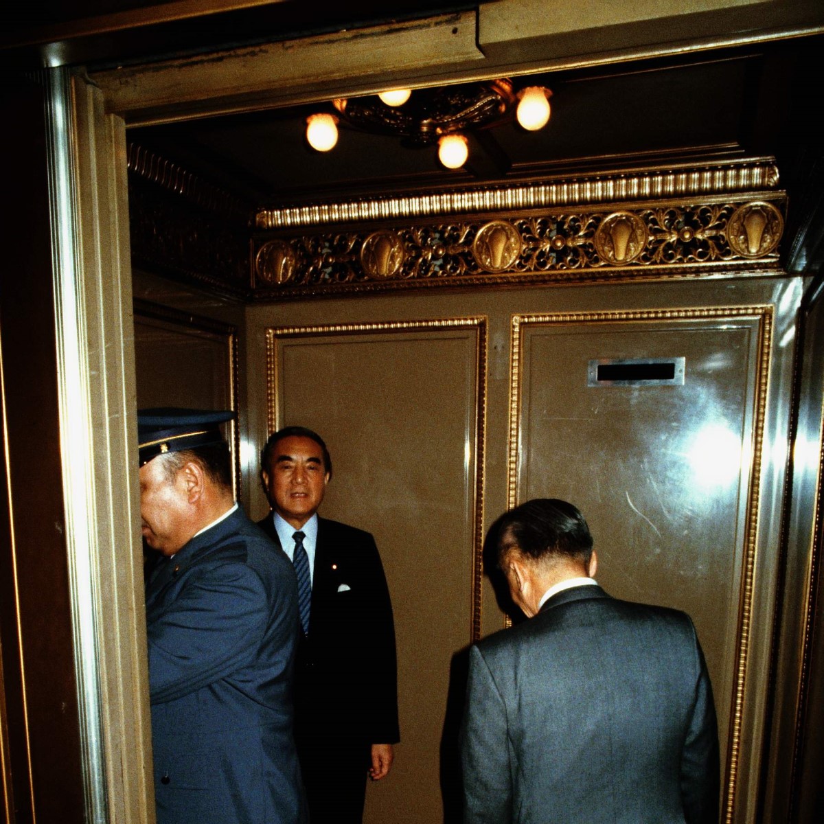 写真・図版 : 1987年、国会内でエレベーターに乗る中曽根康弘首相（奥）と竹下登幹事長（右）＝朝日新聞社