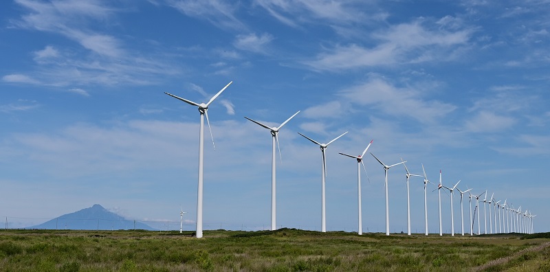 写真・図版 : オトンルイ風力発電所の風車。左奥は海に浮かぶ「利尻富士」＝2020年8月24日、北海道幌延町