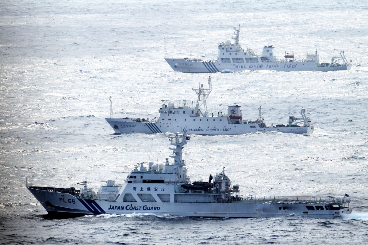 写真・図版 : 2013年、尖閣諸島付近の日本領海を航行する中国海洋監視船（奥の2隻）を警戒し併走する海上保安庁の巡視船（手前）＝朝日新聞社機