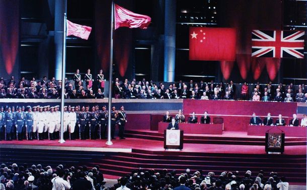 写真・図版 : 香港が中国に返還された1997年7月1日の返還式典会場。香港・湾仔のコンベンションセンターには中国国歌が響き、五星紅旗と香港特別行政区旗が掲揚された。江沢民・中国国家主席は、香港同胞を含むすべての中国人の喜びを宣言した。写真は壇上で演説する江主席