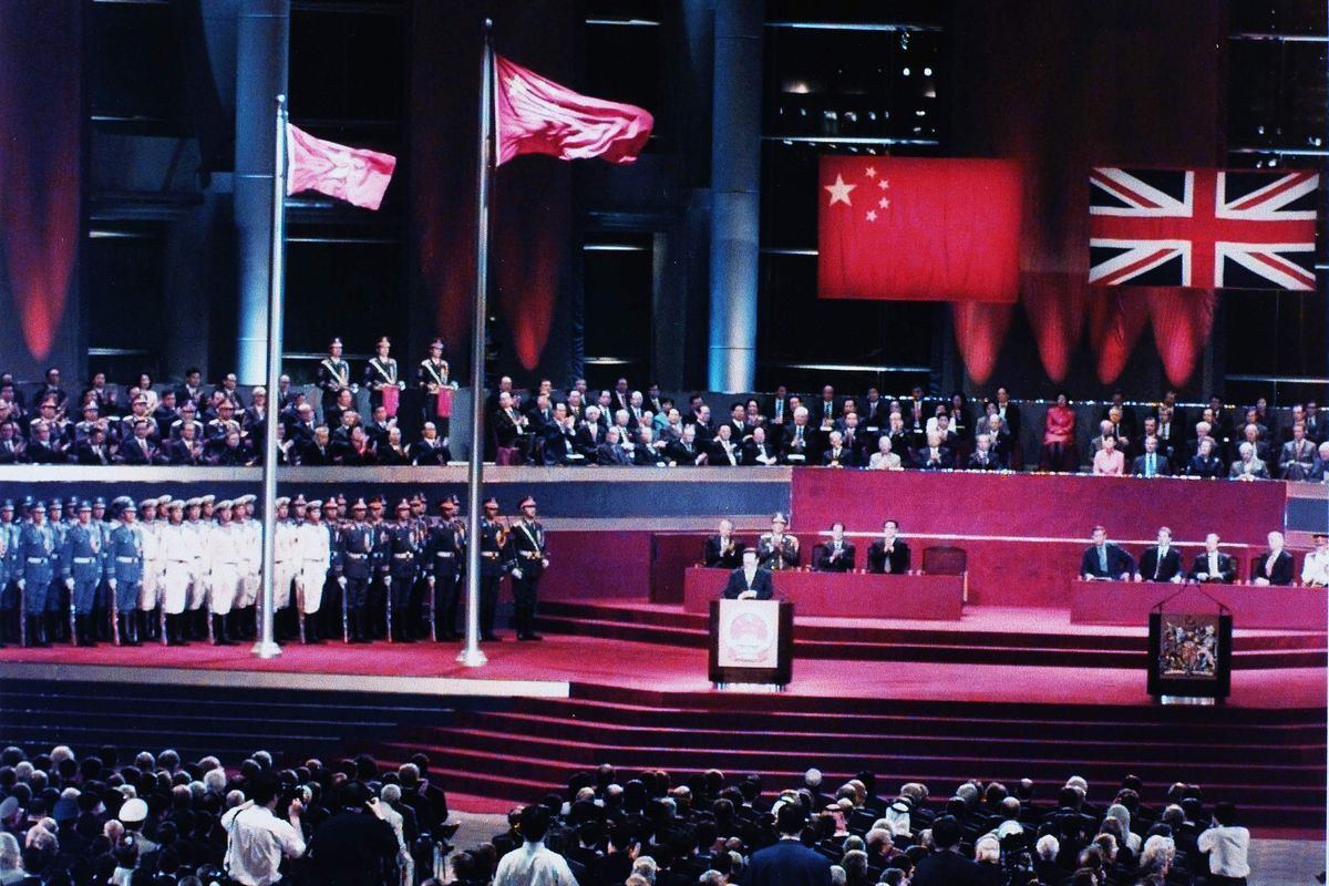 写真・図版 : 香港が中国に返還された1997年7月1日の返還式典会場。香港・湾仔のコンベンションセンターには中国国歌が響き、五星紅旗と香港特別行政区旗が掲揚された。江沢民・中国国家主席は、香港同胞を含むすべての中国人の喜びを宣言した。写真は壇上で演説する江主席