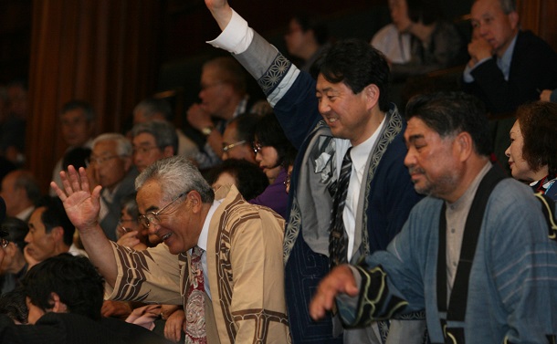 写真・図版 : アイヌ民族を先住民族と認める決議が行われる衆院本会議場で、傍聴席から議員に手を振る北海道ウタリ協会の人たち＝2008年6月6日