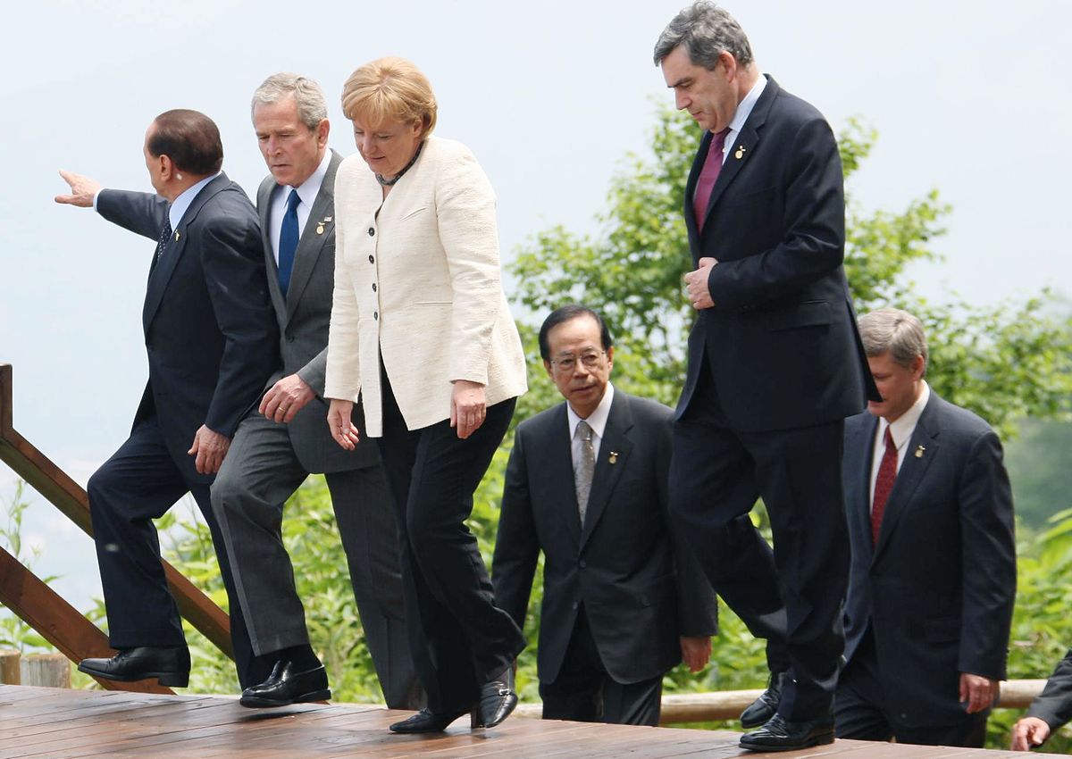 写真・図版 : メルケル氏は15年余りの首相在任中、国際政治の舞台で存在感を保ち続けてきた。写真は北海道洞爺湖サミット会場でベルルスコーニ伊首相、ブッシュ米大統領、ブラウン英首相らと言葉を交わすメルケル氏＝2008年7月