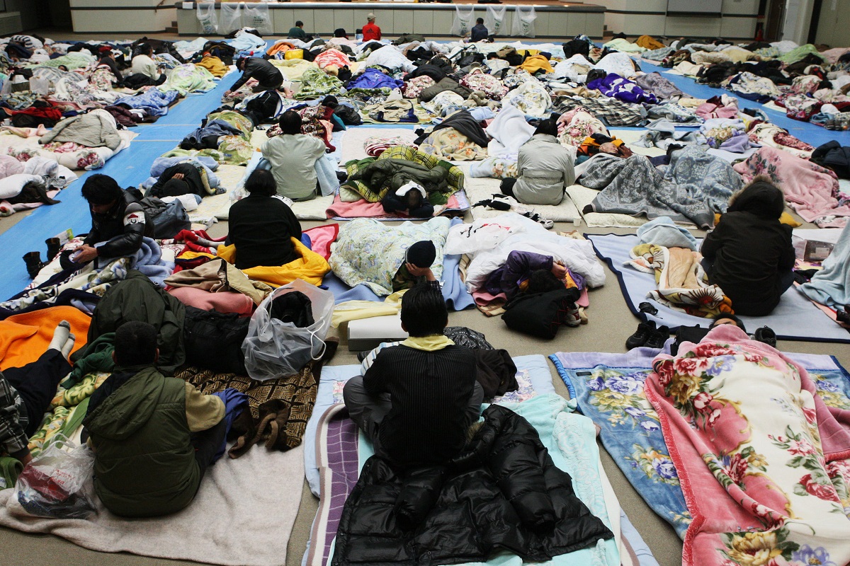 写真・図版 : 「年越し派遣村」が日比谷公園から厚労省の講堂に移動、布団を並べて休む元派遣労働者たち＝2009年1月2日、東京・霞が関 
