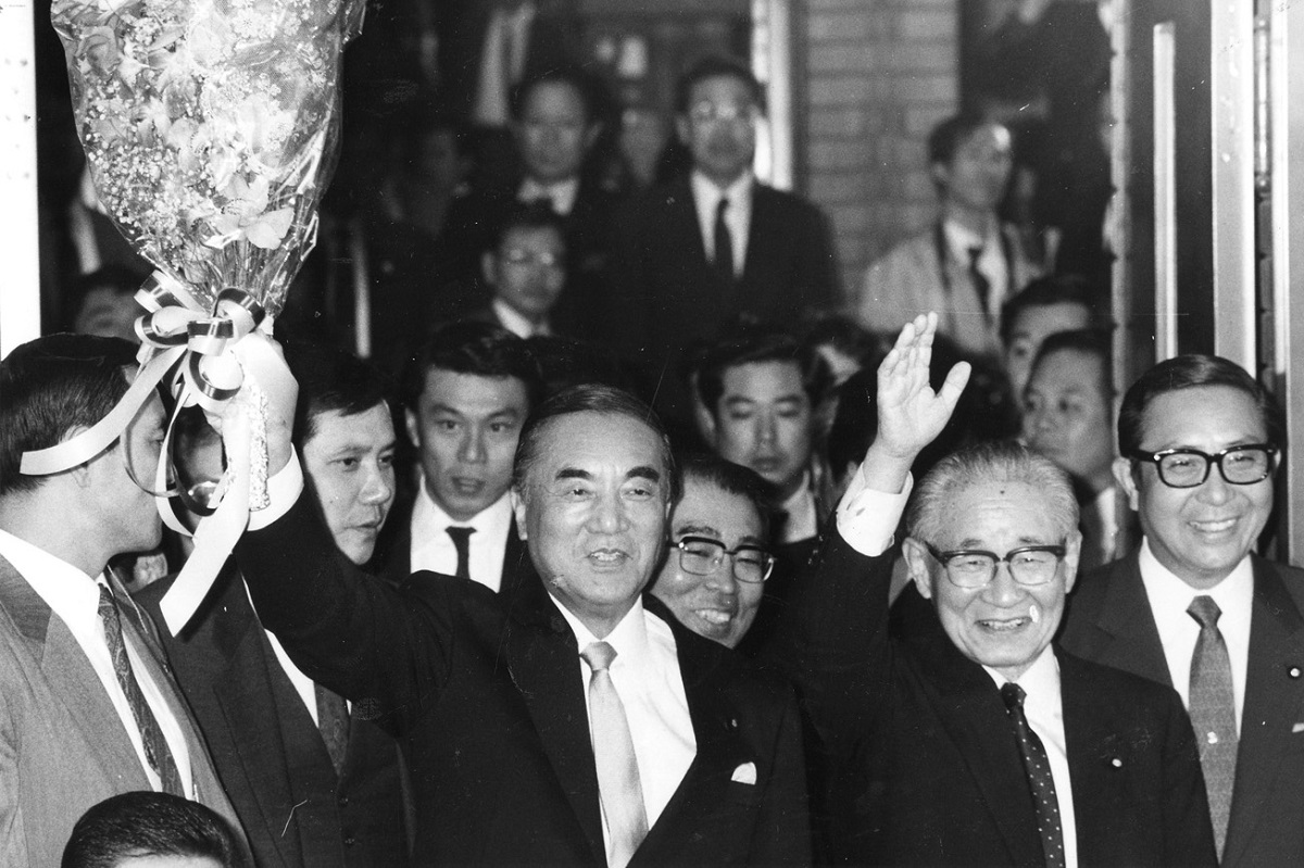 写真・図版 : 首相を退任し官邸を去る中曽根康弘氏（同左）と並んで手を挙げる後藤田正晴氏＝1987年11月6日 