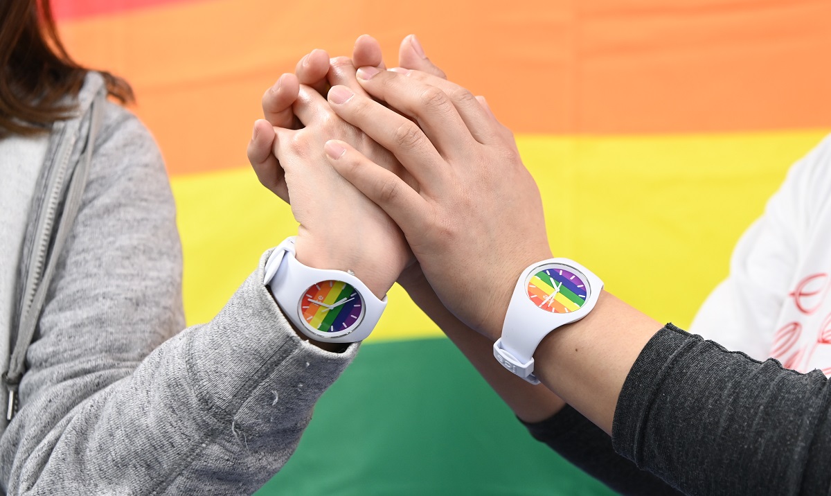 写真・図版 : 「同性婚を認めないのは憲法違反」との札幌地裁判決後の会見を終え、ペアウォッチをはめた手を取り合った原告=2021年3月17日