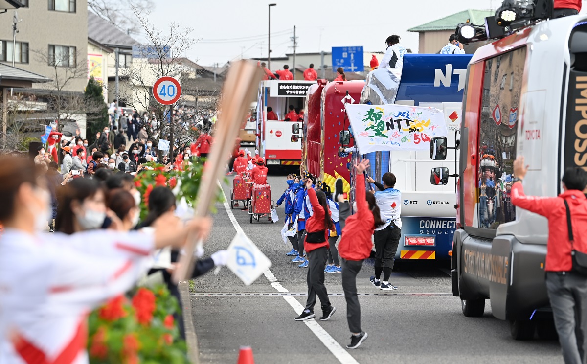 写真・図版 : 聖火リレーで、ランナーの前を「先導」するスポンサー企業の宣伝車両=2021年3月27日、福島県須賀川市