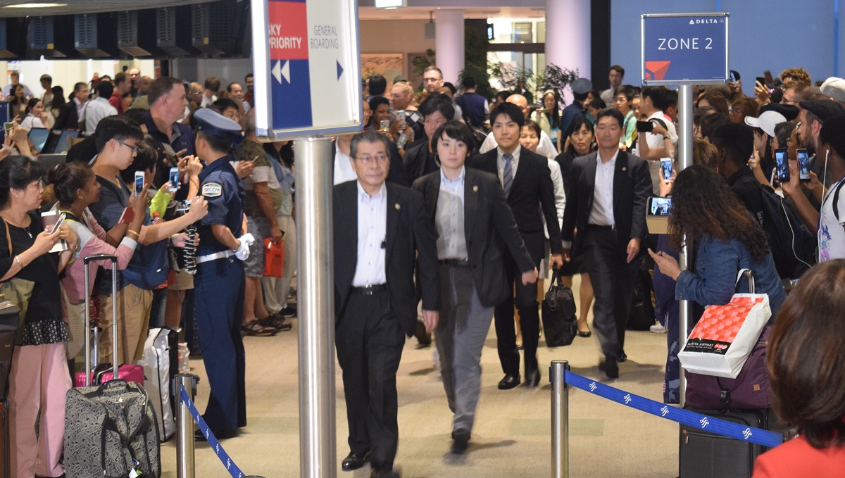 写真・図版 : 米国に向かう小室圭さん(中央列、手前から3人目)=2018年8月7日、成田空港