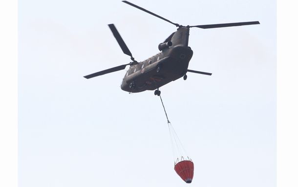 写真・図版 : 事故を起こした福島第一原発へ上空から水を投下するため出動した陸上自衛隊のヘリコプター＝2011年3月17日