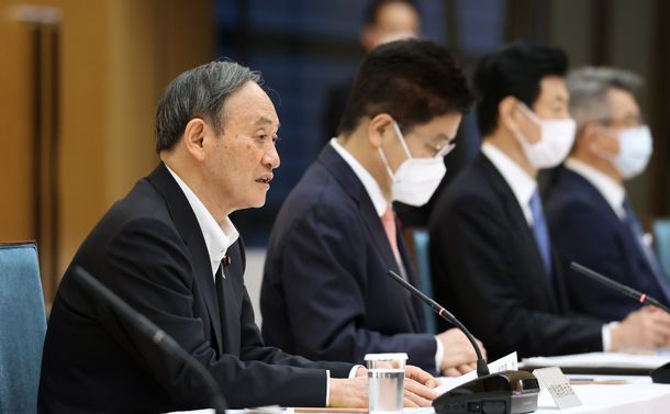 写真・図版 : 新型コロナ感染症対策本部で4都府県の緊急事態宣言延長などを決定したことを伝える菅義偉首相＝2021年5月7日、首相官邸