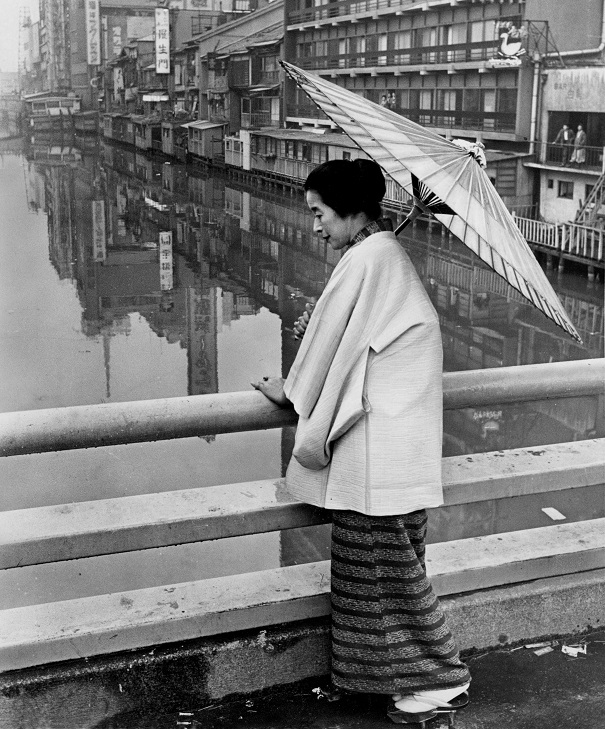 写真・図版 : 道頓堀川の川面を見つめる浪花千栄子さん=1963年
