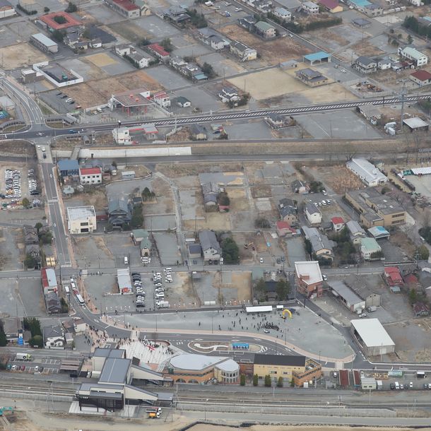 写真・図版 : 聖火リレーがあったJR双葉駅前（下）。住民が戻っていない町内は更地が目立つ＝2021年3月25日、福島県双葉町、朝日新聞社ヘリから