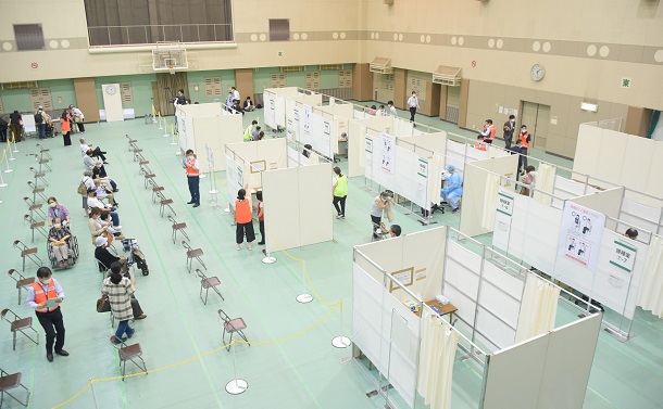 写真・図版 : 大阪市の集団接種会場の一つ、都島スポーツセンターでは、体育館にワクチン接種や問診を行うブースが設置された