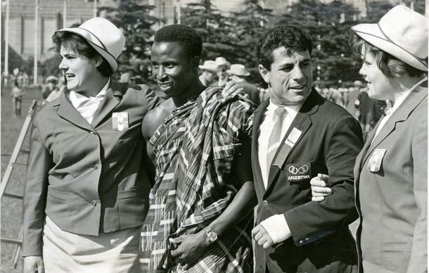 写真・図版 : ガーナ選手の民族衣装は人気を呼んだ。ルーマニア（両端）やアルゼンチンの選手と記念撮影する様子＝1964年10月10日