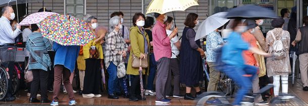 写真・図版 : ワクチンの接種予約が始まった病院の前で列を作る人たち＝2021年5月17日、大阪府堺市