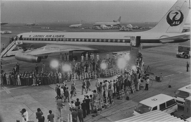 写真・図版 : 1977年、日本赤軍が日航機を乗っ取ったダッカ事件。彼らの要求に日本政府が屈して、刑務所や拘置所から釈放された過激派らが護送機に乗り込む＝1977年10月1日、東京都・羽田空港