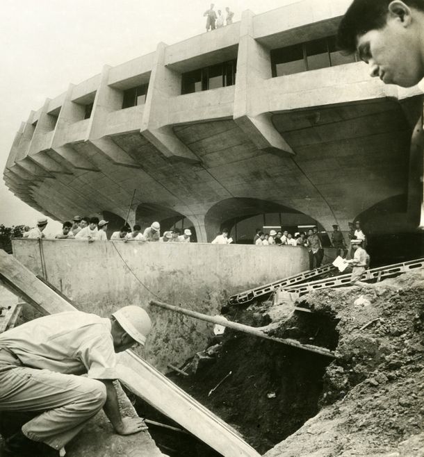 写真・図版 : 1964年、東京・代々木体育館わきで土砂が崩れ、生き埋め事故が発生した現場。テレビ用電線を修理するため、深さ4mの穴を掘って故障箇所を点検中、周囲に積んであった土砂が崩れ、2人が生き埋めになり1人が死亡した＝1964年9月10日、東京都・渋谷区