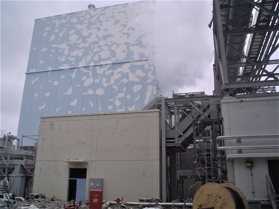 写真・図版 : 原子炉建屋の開口部から煙を噴き出す福島第一原発２号機＝２０１１年３月１５日に東電社員が撮影し、２０１３年２月１日に同社から公表された写真