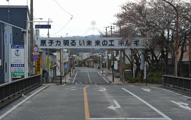 写真・図版 : 人の気配がなくなった福島県双葉町の商店街。「原子力明るい未来のエネルギー」の看板がかかっていた＝2011年4月25日