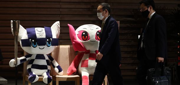 写真・図版 : 首相官邸を出る菅義偉首相。エントランスホールには東京五輪・パラリンピックのマスコット人形が飾られている＝2021年3月3日