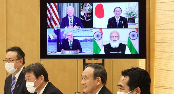 写真・図版 : 日米豪印首脳のオンライン会談。菅義偉首相（右から2人目）。画面内は（右下から時計回りに）モディ印首相、モリソン豪首相、バイデン米大統領＝2021年3月12日