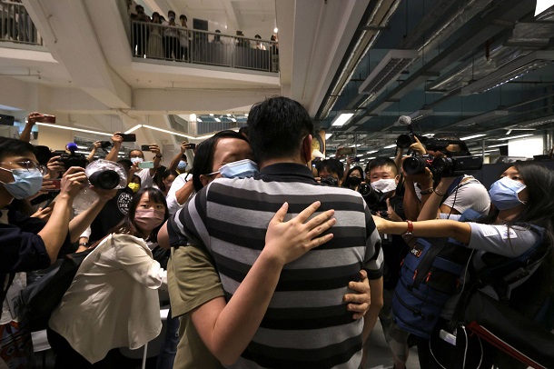写真・図版 : 23日23時40分、「蘋果日報」最終号を組み終えたあと、感極まって抱き合う編集スタッフ。フロアには国内外の報道者数十人が詰めかけている
