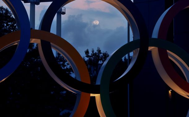 写真・図版 : 五輪マークのオブジェの奥に浮かぶ月＝2021年6月23日、東京都新宿区