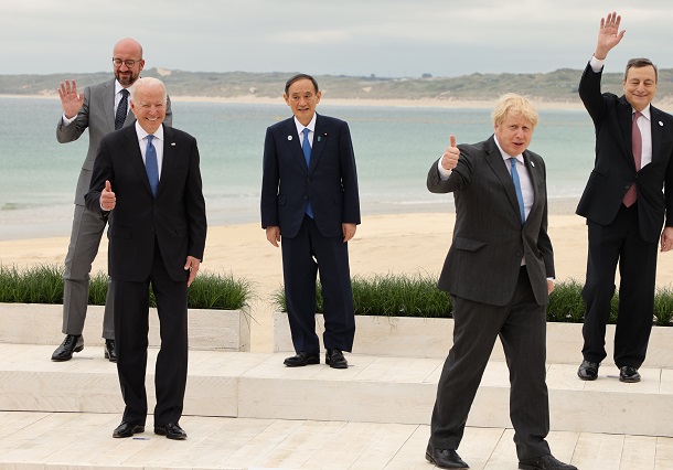 写真・図版 : G7首脳会議。各国首脳との記念撮影を終え、笑顔を見せる菅義偉首相（中央）。前列左はバイデン米大統領、同右は議長のジョンソン英首相＝2021年6月11日、英国・コーンウォール 
